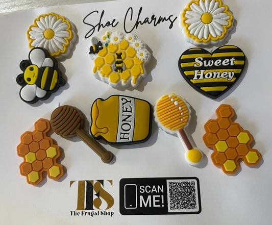 Set of shoe charms with bee, honeycomb, and flower designs on a white card.
