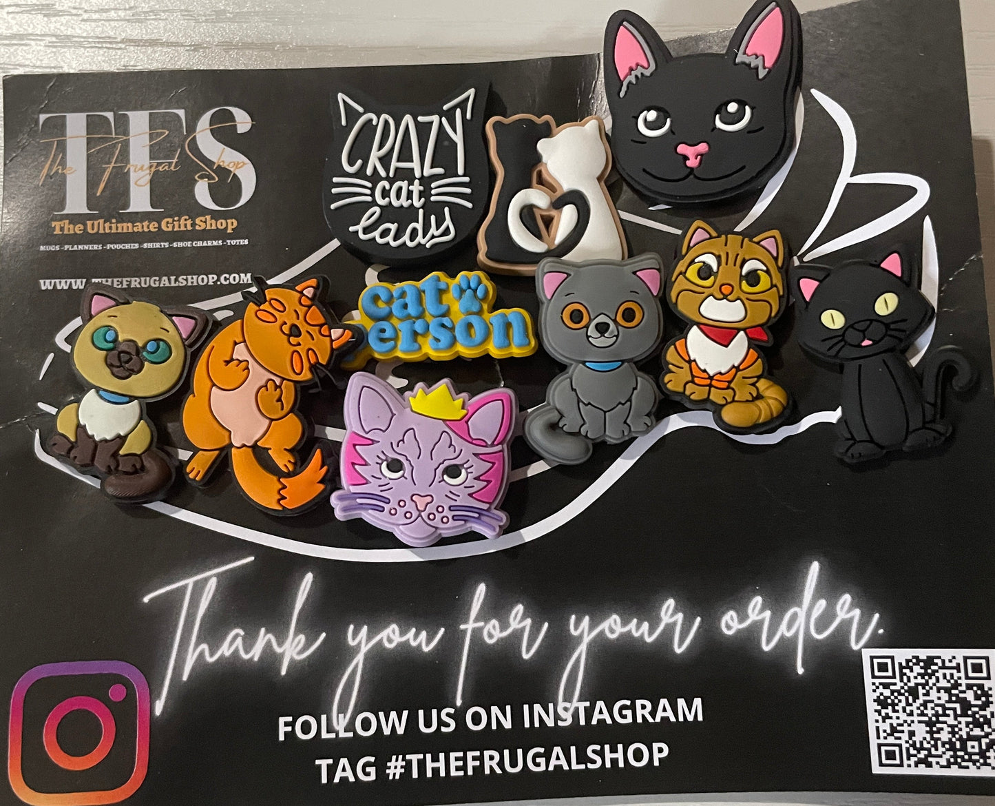 Set of cat-shaped pins on a black card with branding and QR code.