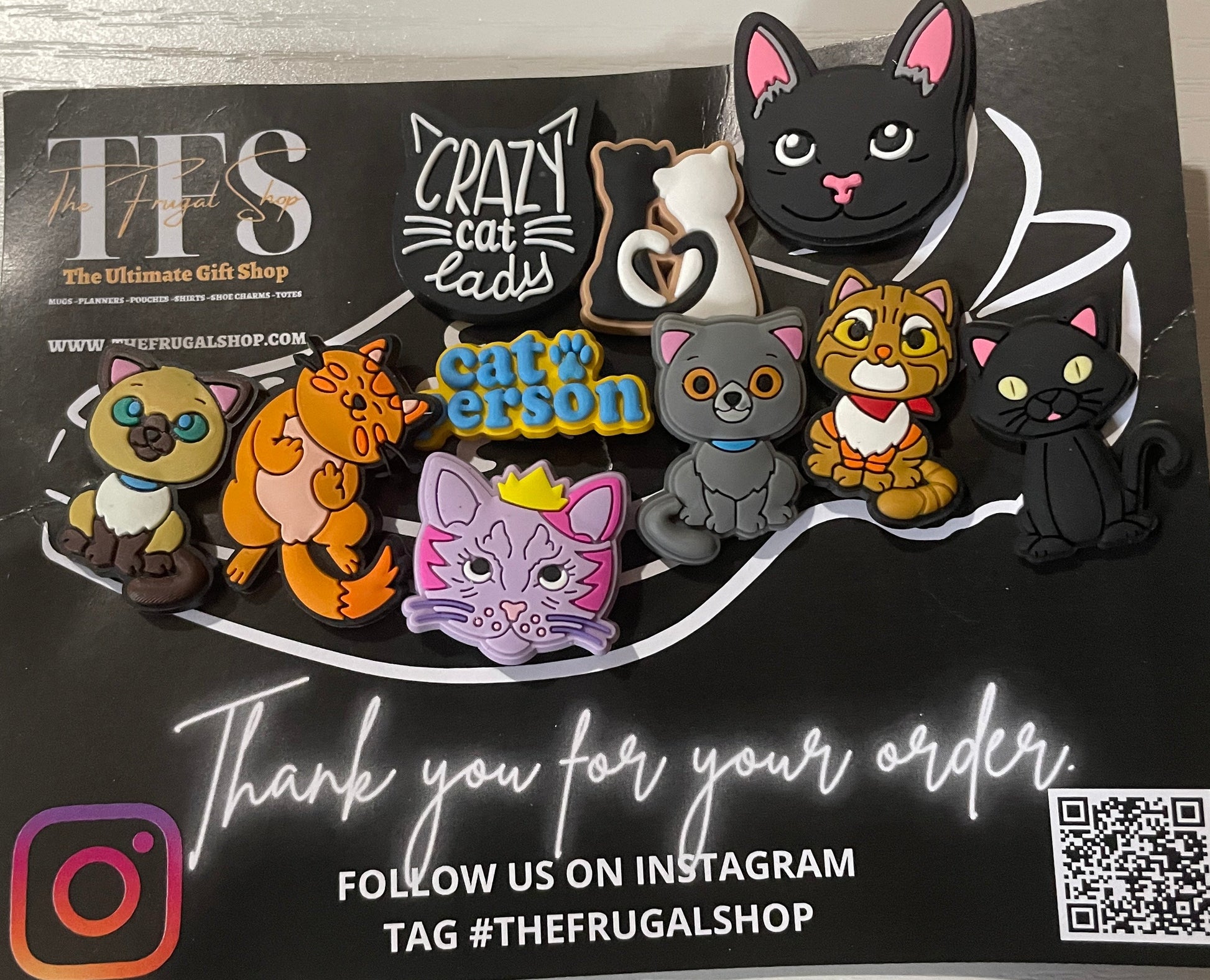 Set of cat-shaped pins on a black card with branding and QR code.