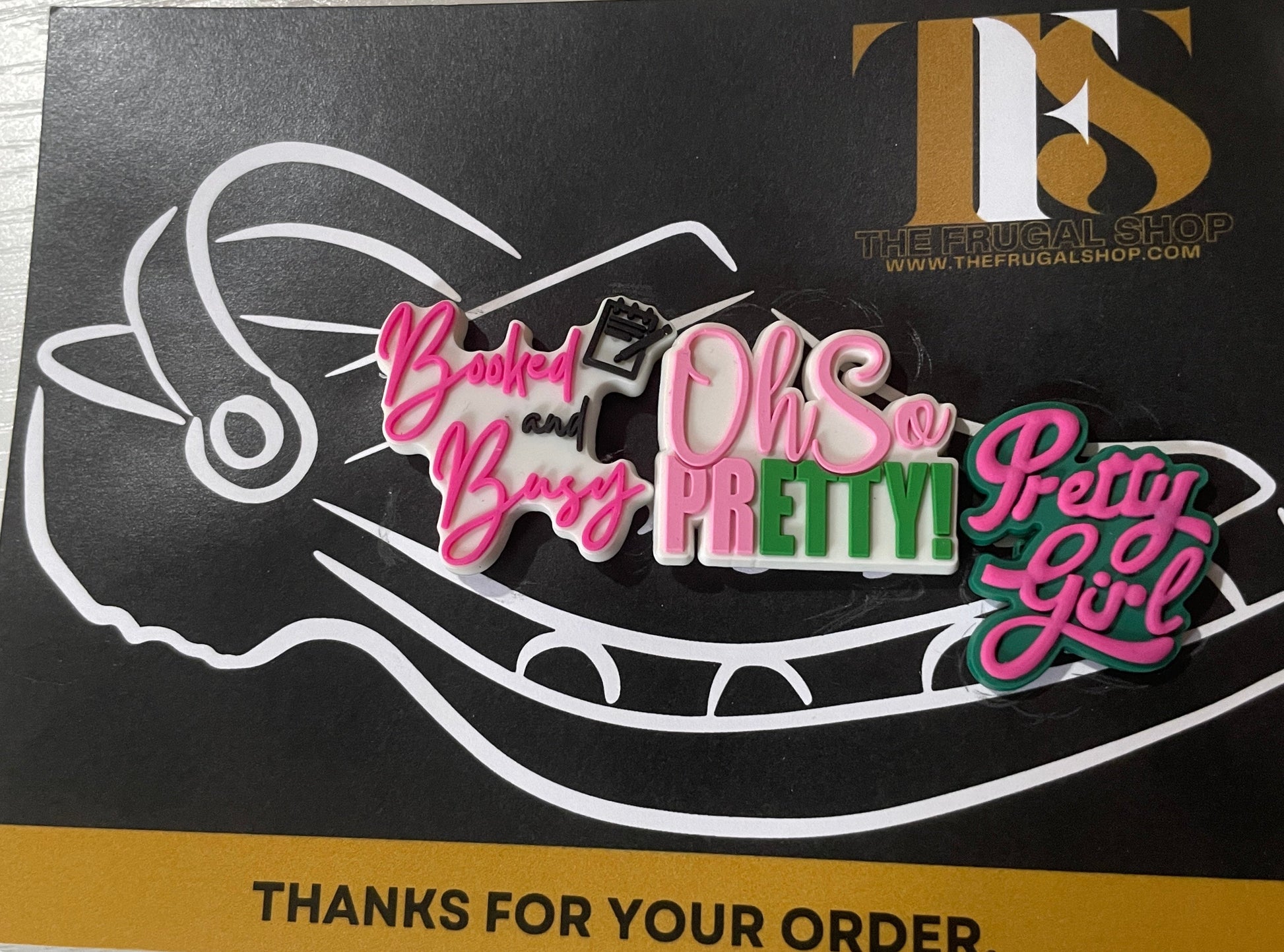 Colorful 'Pretty Little Liars' pins on a branded card with text.