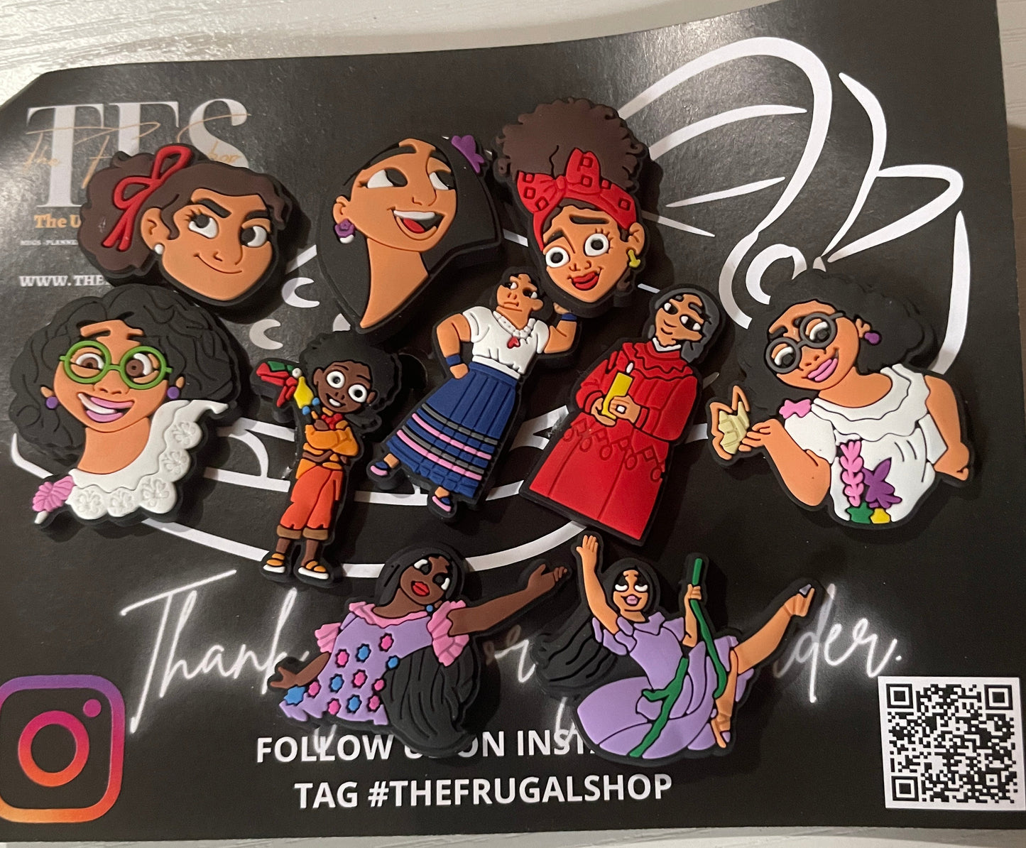 Set of colorful figurines on a black card with branding and QR code.