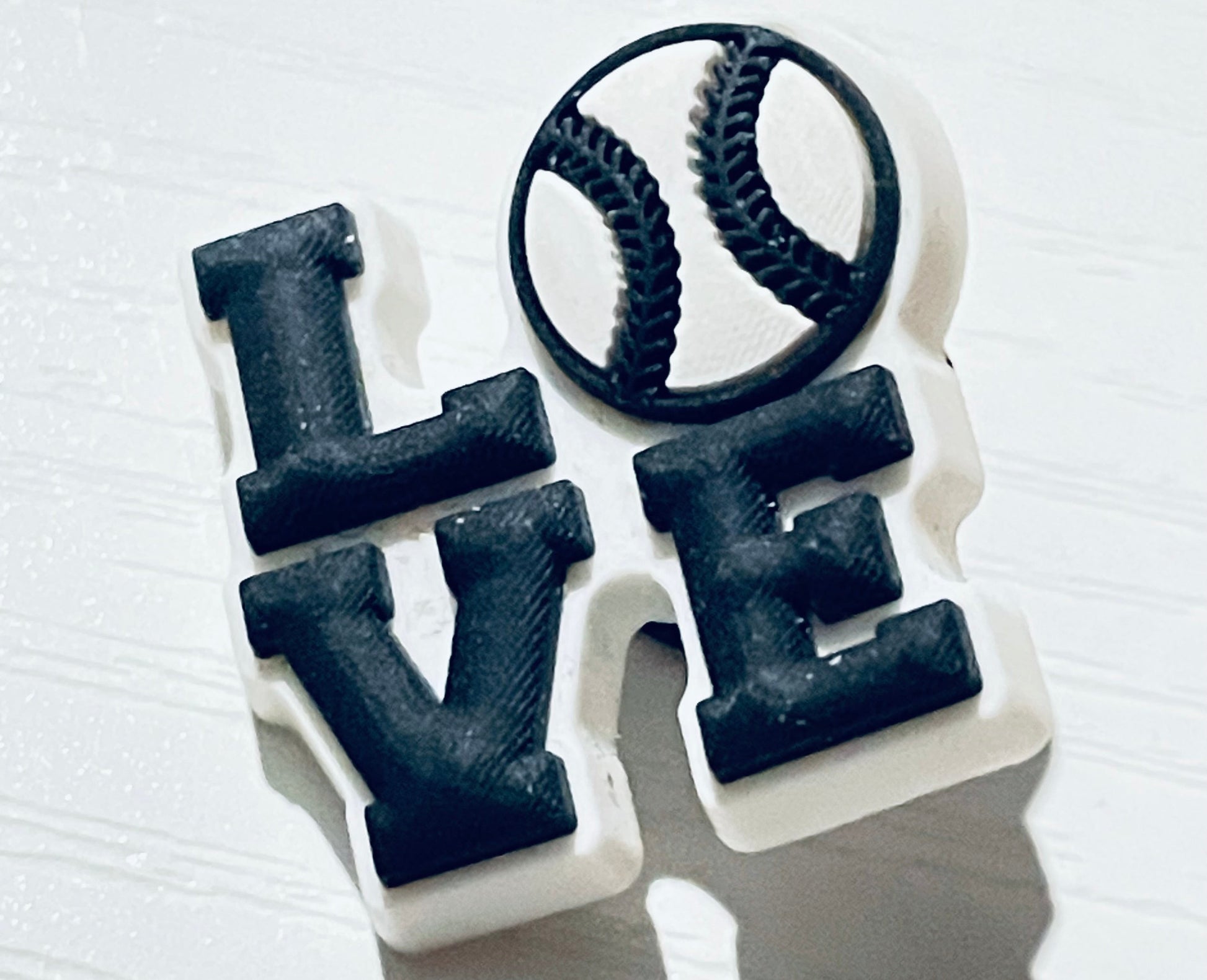 Black 'LOVE' letter beads on a white background
