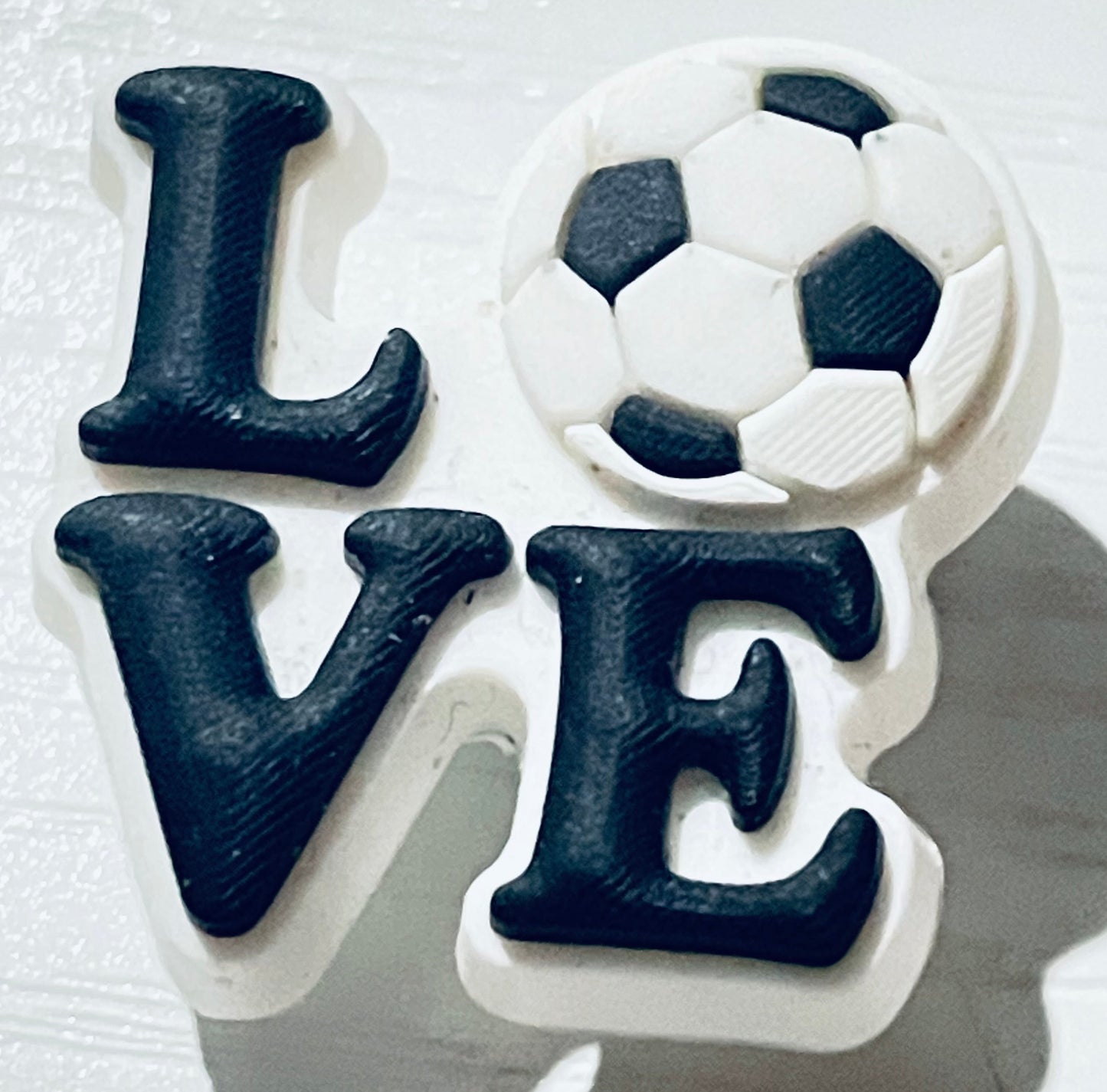 Decorative letters spelling 'LOVE' with a soccer ball on a light background